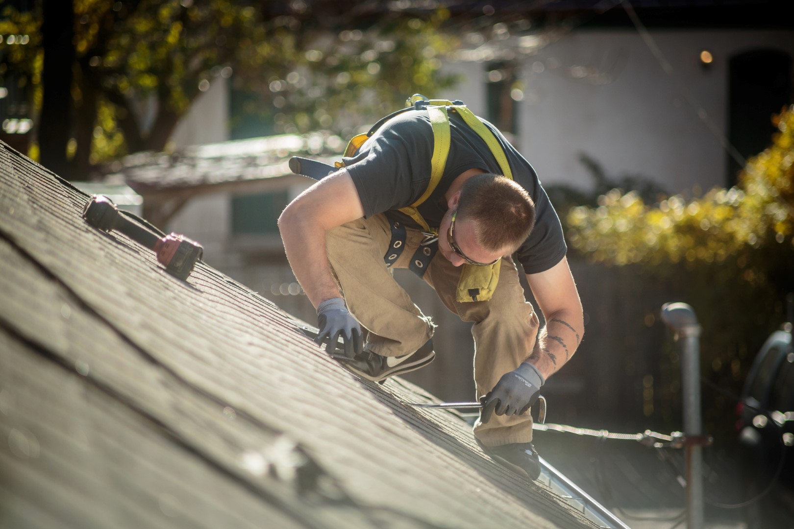 Solar panel installation worker working on roof of house