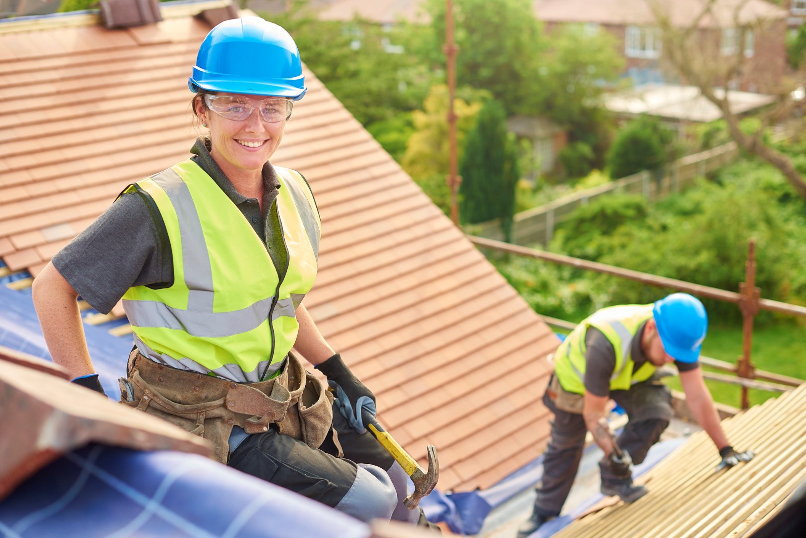 female roofer replacing roof tiles