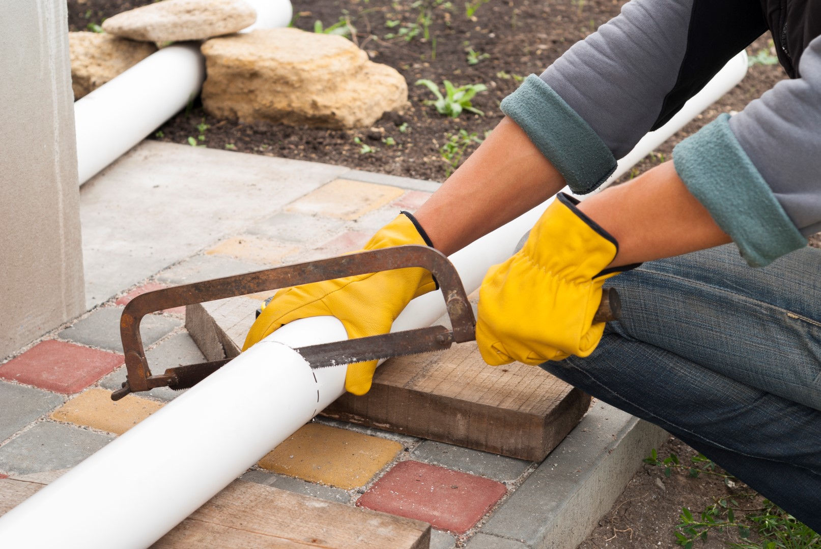 construction worker cuts the pipe gutter system